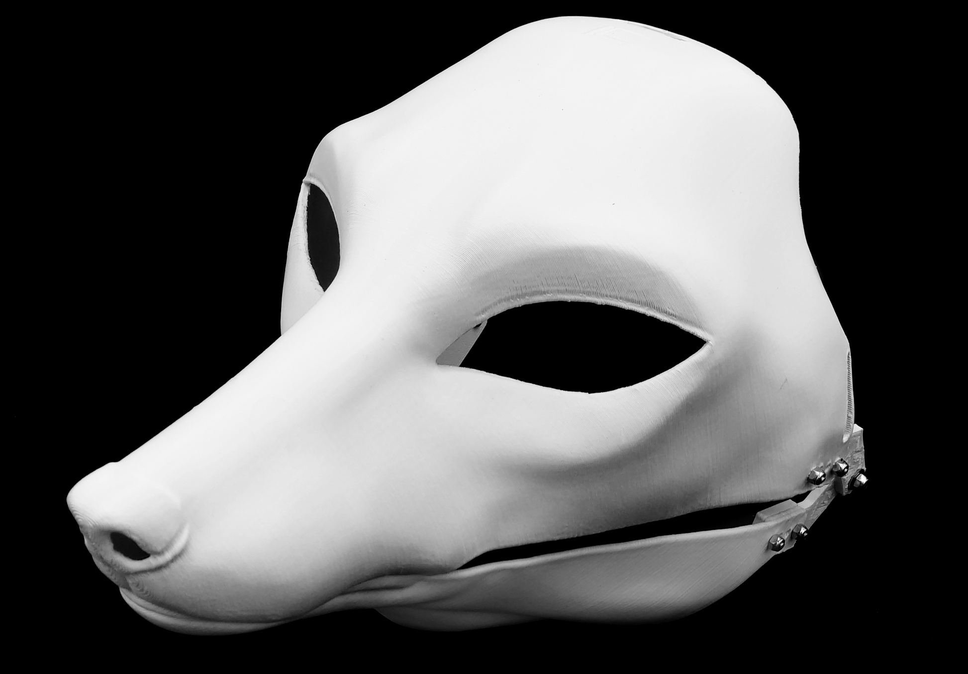 Photo showing a white, plastic 3D printed fox fursuit head base complete with metal hardware at a 3/4 angle against a black background.