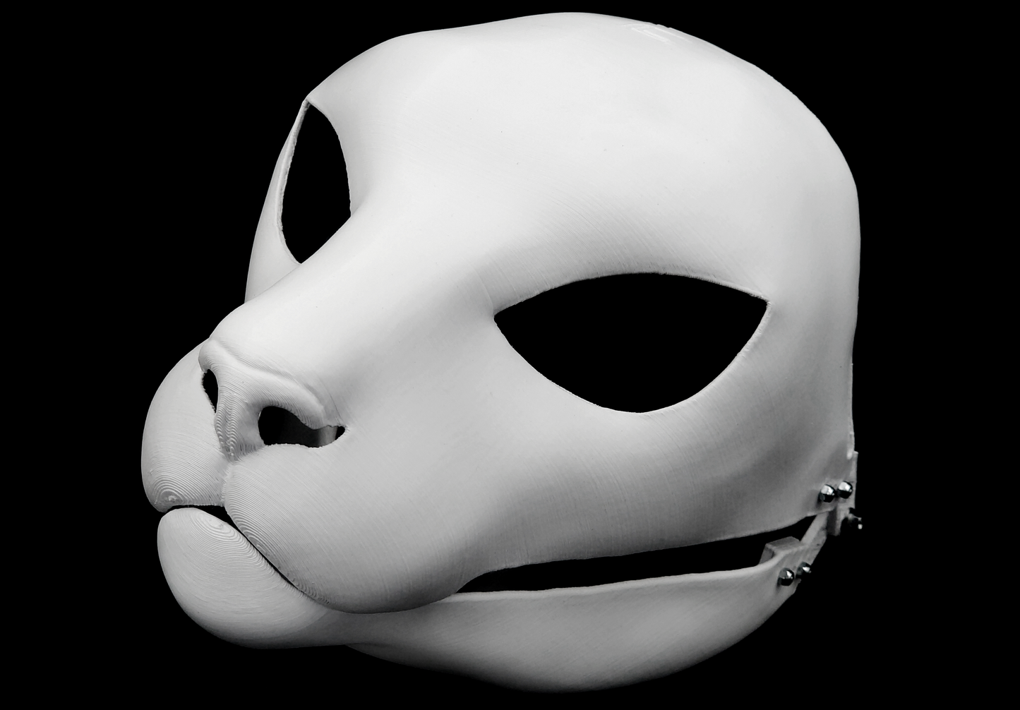 Photo showing a white, plastic 3D printed small feline fursuit head base complete with metal hardware at a 3/4 angle against a black background.