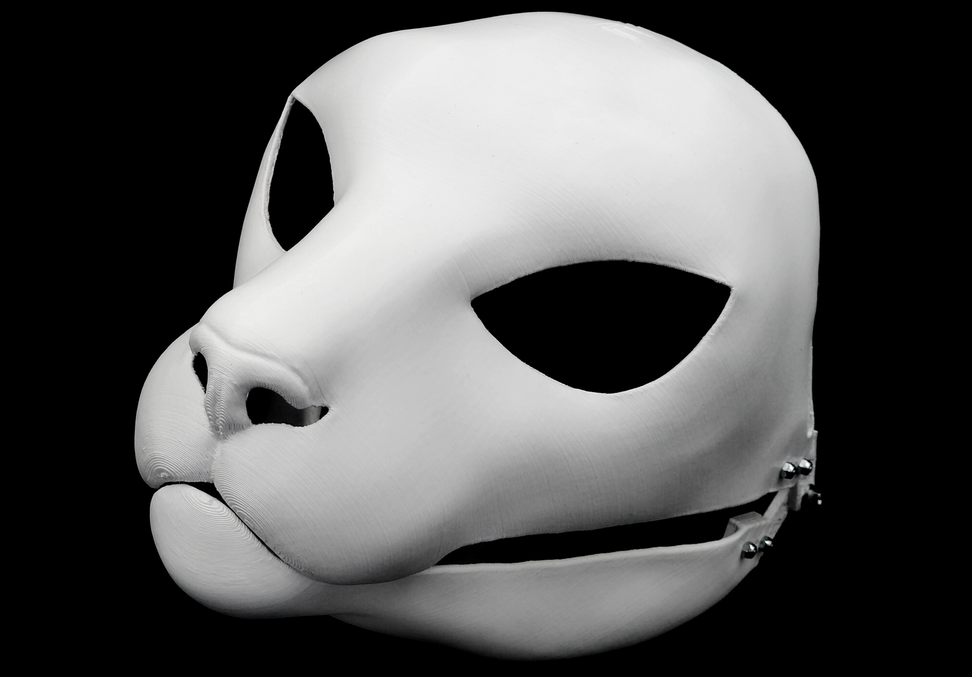 Photo showing a white, plastic 3D printed small feline fursuit head base complete with metal hardware at a 3/4 angle against a black background.