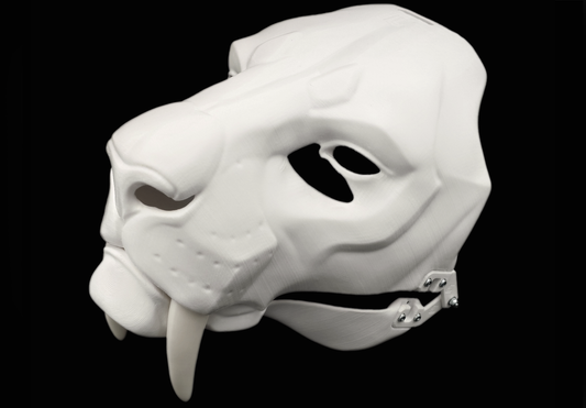 Photo showing a white, plastic 3D printed smilodon fursuit head base complete with metal hardware at a 3/4 angle against a black background.