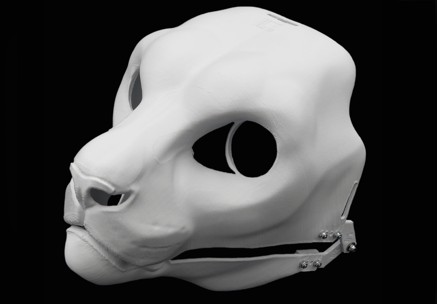 Photo showing a white, plastic 3D printed snow leopard fursuit head base complete with metal hardware at a 3/4 angle against a black background.